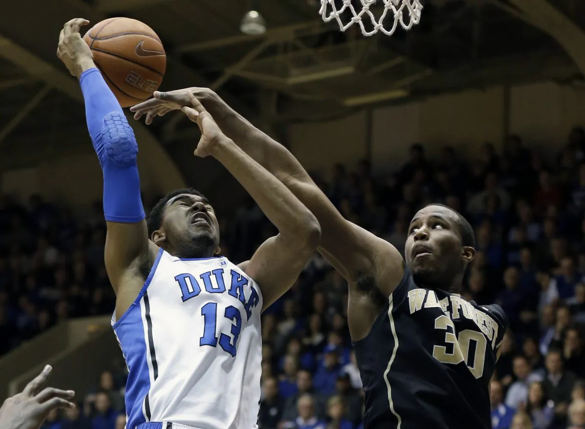 Duke's Matt Jones (13) is blocked by Wake Forest's Travis McKie (30) during the first half of an NCAA college basketball game in Durham, N.C., Tuesday, Feb. 4, 2014. (AP Photo/Gerry Broome)
