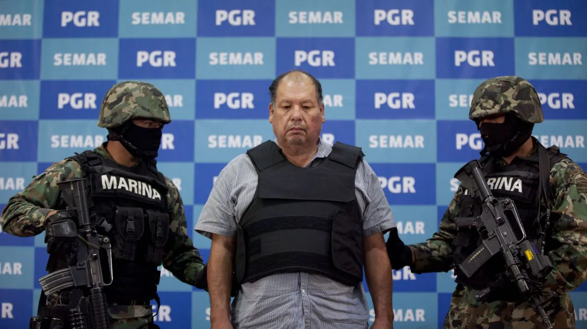 Arrested drug boss Mario Cardenas Guillen, also known as "El Gordo," is escorted by Mexican Navy officers in Mexico City, Sept. 4, 2012. Ingredients for methamphetamine, from China, help the Mexican drug trade. (AP Photo/Alexandre Meneghini)