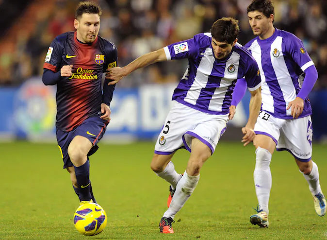 FC Barcelona's Lionel Messi from Argentina, left, duels for the ball next to Real Valladolid's Henrique Sereno from Portugal and Óscar González, right, during a Spanish La Liga soccer match at the Jose Zorrilla stadium in Valladolid, Spain, Sat., Dec. 22, 2012. (AP Photo/Israel l.Murillo)