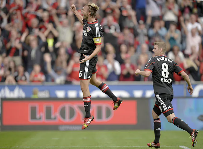 Leverkusen's Simon Rolfes, left, celebrates after scoring during the German soccer Bundesliga match between Bayer Leverkusen and Hanover 96 in Leverkusen, Germany, Saturday, Sept. 28, 2013. (AP Photo/Martin Meissner)