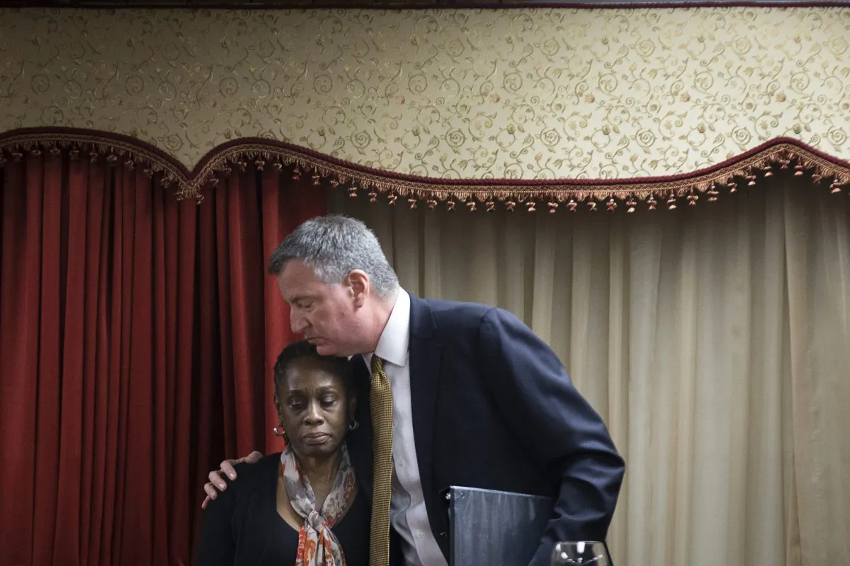 New York City Mayor Bill de Blasio (R) hugs his wife, Chirlane McCray, after speaking at the Church of God of Third Avenue as the congregation welcomed members of the Spanish Christian Church after the church was destroyed by Wednesday's explosion in the East Harlem neighborhood of New York, March 16, 2014. (AP Photo/John Minchillo)