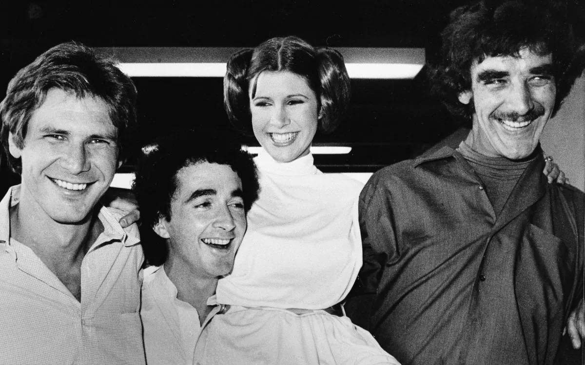 From left, Harrison Ford who played Han Solo, Anthony Daniels who played the robot C3P0, Carrie Fisher who played Princess Leia, and Peter Mayhew who played the Wookie, Chewbacca, are shown during a break from the filming of a television special presentation in Los Angeles, Ca., Oct. 5, 1978. (AP Photo)