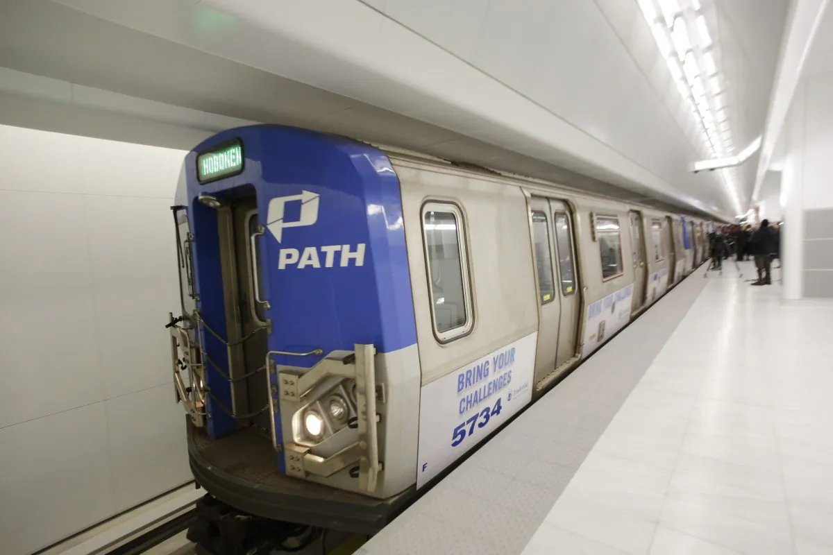 A commuter train leaves a newly-opened platform at the World Trade Center's PATH station, Tuesday, Feb. 25, 2014, in New York. The new platform will link towns in New Jersey with the World Trade Center's transportation hub, still under construction. The fully modernized platform A features new lighting, speakers, illuminated signs, escalators and elevators. (AP Photo/Mark Lennihan)