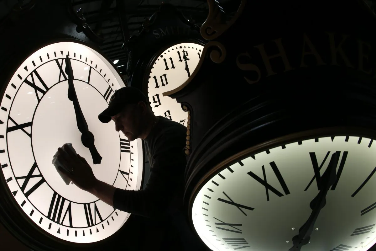 Dave LeMote wipes down a post clock at Electric Time Company, Inc. in Medfield, Mass., on March 7, 2014. Most Americans will set their clocks 60 minutes forward before heading to bed Saturday night, but daylight saving time officially starts Sunday at 2 a.m. (Elise Amendola/AP Photo)