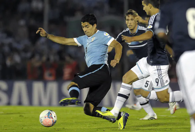 Uruguay's Luis Suarez, left center, fights for the ball with Argentina's Erik Lamela, right, as Lucas Biglia follows, during a 2014 World Cup qualifying soccer game in Montevideo, Uruguay, Tuesday, Oct. 15, 2013. (AP Photo/Matilde Campodonico)