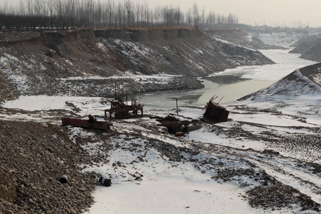 Discarded machinery parts are seen in the Juma river after gravel mining operations, Jan. 8, 2013. Many waterways in China have become heavily contaminated with toxic waste. (STR/AFP/Getty Images)