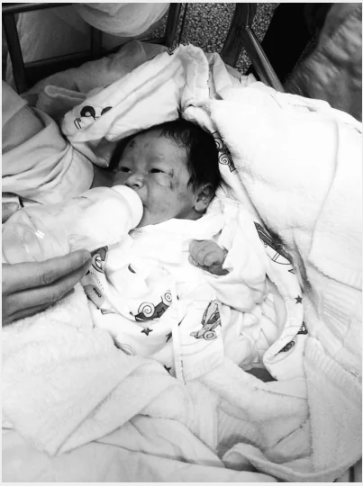 Screenshot showing a newborn baby in hospital, after he was found at a crash site where his parents died, when a truck hit their motorbike. (Screenshot/WhatsOnXiamen)