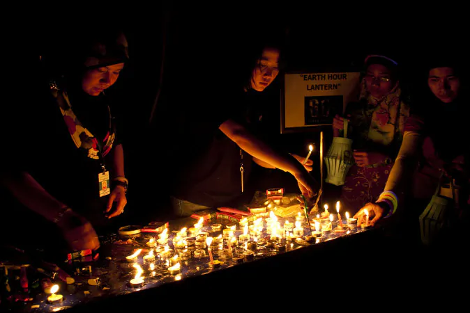 Women light candles as the lights go out in Kuala Lumpur, Malaysia, to celebrate Earth Hour in 2011. Earth Hour 2014 will be on Saturday, March 29 from 8:30-9:30 p.m. local time. (Shutterstock*)