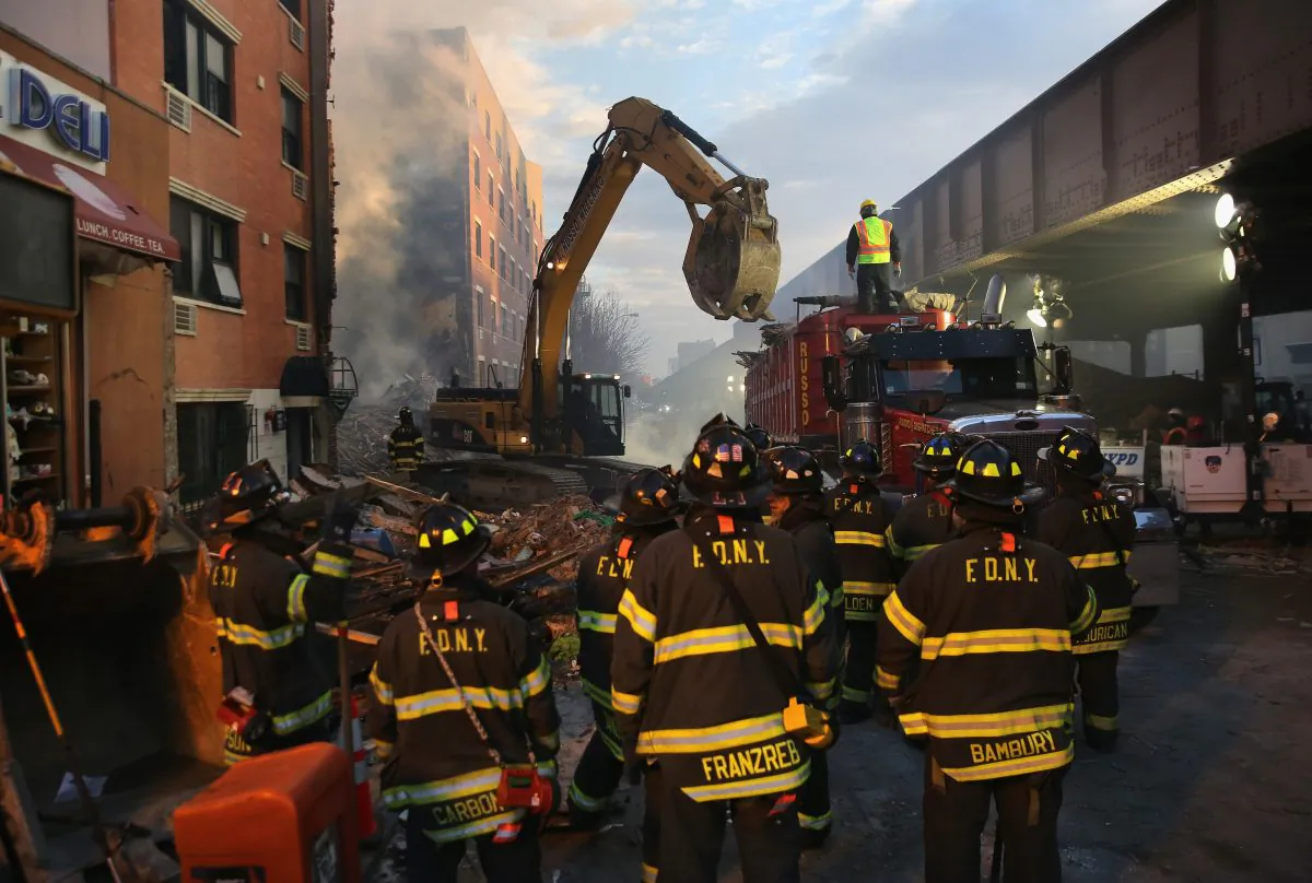 Firemen watch as work crews remove debris from the site of an explosion in East Harlem Thursday, March 12, 2014. (John Moore/Getty Images)