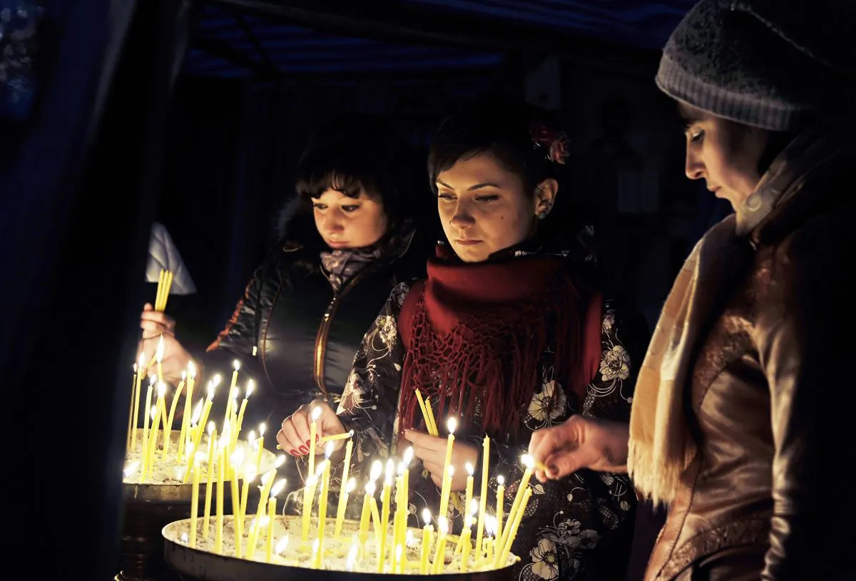 Young women light candles at a makeshift shrine in Kyiv’s Independence square as protests continued nearby on March 2, 2014. (Louisa Gouliamaki/AFP/Getty Images)