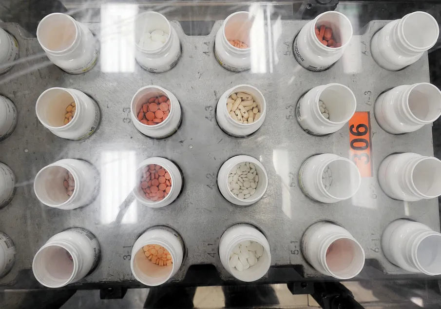 Bottles of prescription pills go through an automated packaging machine in the Medco pharmacy plant in Willingboro, New Jersey, December 2, 2010. (STAN HONDA/AFP/Getty Images)
