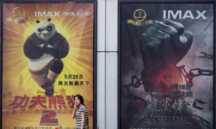 A woman walks past a movie poster of "Kung Fu Panda 2" and China's propaganda film "Beginning of the Great Revival" outside a cinema in Beijing, on June 15, 2011. Dreamworks is partnering with China's state-run Shanghai Media Group to create "Kung Fu Panda 3." (Andy Wong/AP Photo)