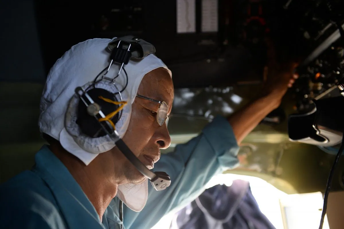 A Vietnamese air force pilot touches the controls of a transport plane Sunday during a search and rescue operation for the Malaysian airliner that vanished early Saturday. (AP Photo)