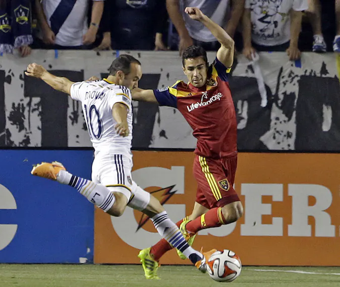 Real Salt Lake defender Tony Beltran covers as Los Angeles Galaxy midfielder Landon Donovan attacks in the first half of an MLS soccer game in Carson, Calif., Saturday, March 8, 2014.  Real Salt Lake won, 1-0. (AP Photo/Reed Saxon)