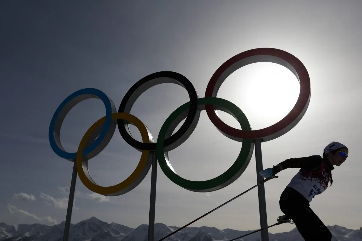 In this file photo dated Thursday, Feb. 20, 2014, a skier passes by the Olympic rings at the 2014 Winter Olympics, in Krasnaya Polyana, Russia. (AP Photo/Felipe Dana)