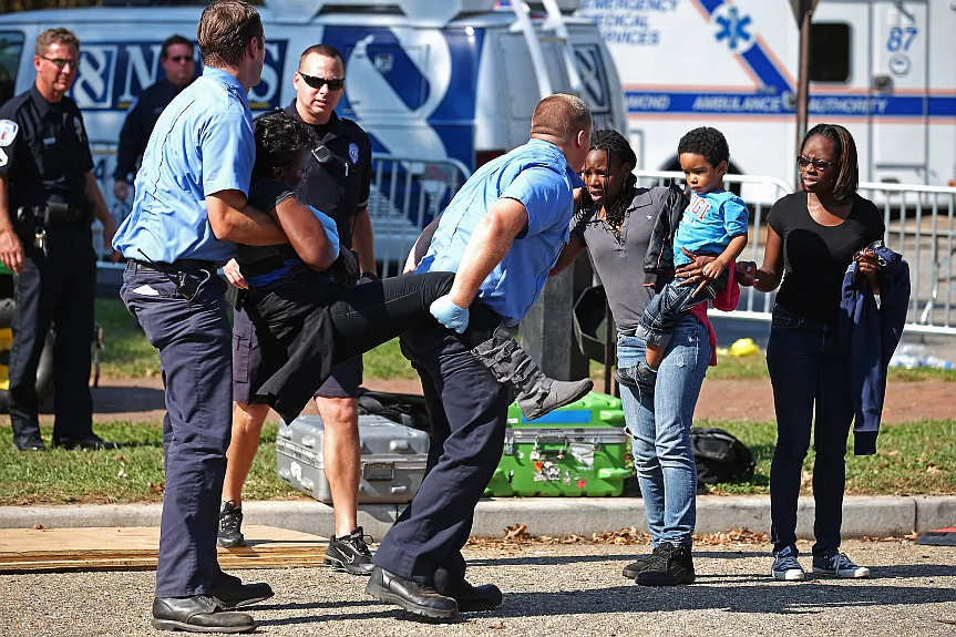 Paramedics carry a woman overcome by heat during a campaign rally with President Barack Obama in Richmond, Va., Oct. 25, 2012. (Chip Somodevilla/Getty Images)