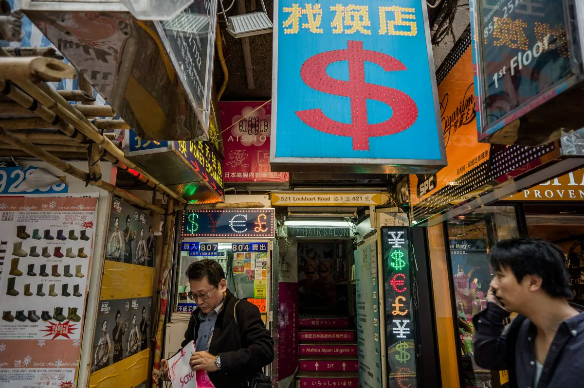 A man (L) leaves a currency exchange booth in Hong Kong on November 22, 2012. (Philippe Lopez/AFP/Getty Images)