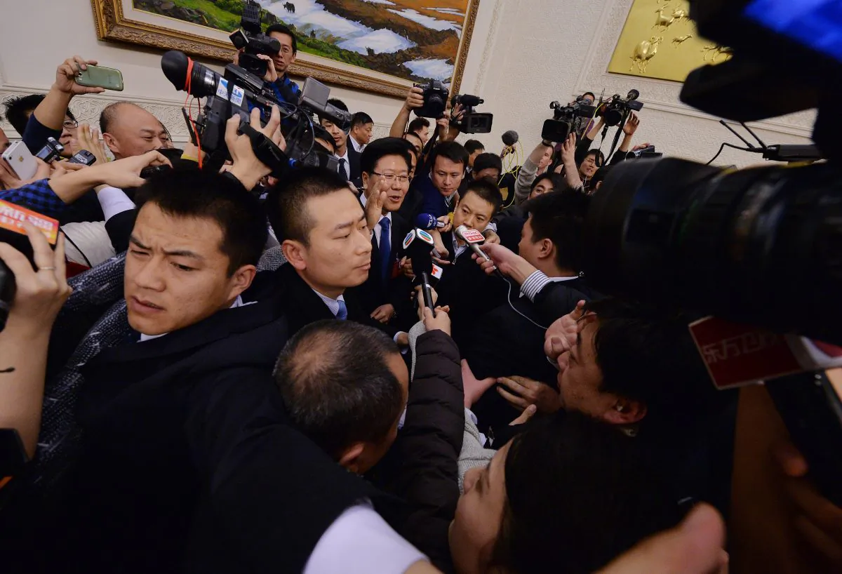 Journalists mob Xinjiang Communist Party Secretary Zhang Chunxian (center with glasses) as they try to ask questions about the recent terror attack in Kunming at the Great Hall of the People in Beijing on March 6, 2014. (Mark Ralston/AFP/Getty Images)