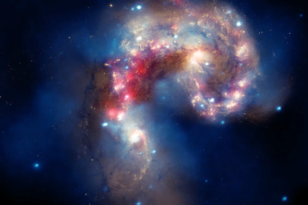 Two galaxies collide in this image released by NASA's Great Observatories. The Antennae galaxies, located about 62 million light years from Earth, are shown in this composite image from the Chandra X-ray Observatory (blue), the Hubble Space Telescope (gold and brown), and the Spitzer Space Telescope (red). The Antennae galaxies take their name from the long antenna-like "arms," seen in wide-angle views of the system. These features were produced by tidal forces generated in the collision. (X-ray: NASA/CXC/SAO/J.DePasquale; IR: NASA/JPL-Caltech; Optical: NASA/STScI)
