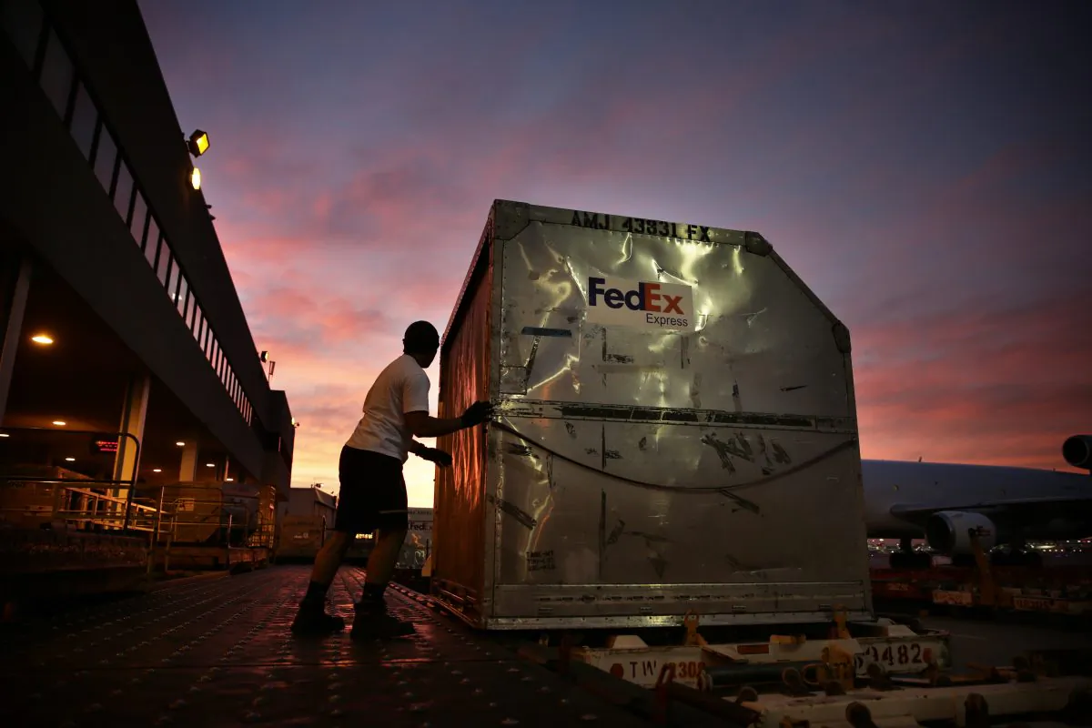 In this Monday, Dec. 2, 2013, file photo, a worker loads a container onto a FedEx cargo plane at the FedEx hub at Los Angeles International Airport in Los Angeles. (AP Photo/Jae C. Hong, File)