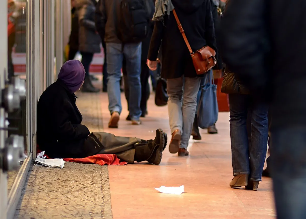 A man begging for money sits on the pavement in Berlin, on Dec. 20, 2012. Some Romanians are being lured to Germany on false promises to beg on the streets for “employers.” (Britta Pedersen/AFP/Getty Images)