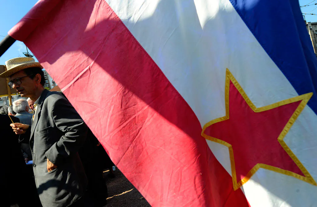 A man behind the flag of the former communist Yugoslavia attends a celebration of the May Day in Belgrade, on May 1, 2010. On the eve of the 30th anniversary of Tito's death many of his followers gather on various places remembering of past era. (Andrej Isakovic/AFP/Getty Images)