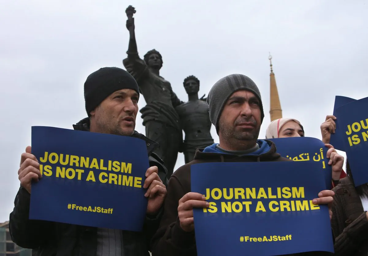 Two Lebanese cameramen who work for Al Jazeera hold placards to show their solidarity with journalists detained by Egyptian authorities during a sit-in in downtown Beirut on Feb. 27, 2014. Egyptian-Canadian journalist Mohamed Fahmy is on trial in Egypt with two Al-Jazeera English journalists and 17 other defendants on terrorism-related charges. (AP Photo/Hussein Malla)