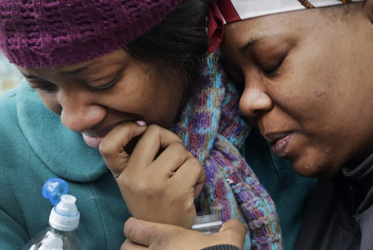 Alecia Thomas, left, is comforted by her friend, Shivon Dollar, after she lost her home following an explosion that leveled two apartment buildings in the East Harlem neighborhood of New York, Wednesday, March 12, 2014. Con Edison spokesman Bob McGee says a resident from a building adjacent to the two that collapsed reported that he smelled gas inside his apartment, but thought the odor could be coming from outside. (AP Photo/Mark Lennihan)