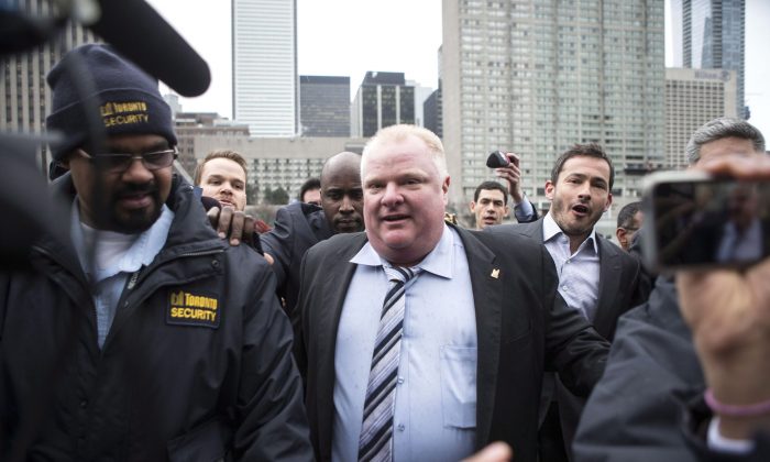 Toronto Mayor Rob Ford is pursued by the media outside city hall in Toronto on Wednesday, March 19, 2014. A video of Ford smoking what appears to be crack cocaine was found on the laptop of an alleged gang member, who also apparently filmed himself describing how to "catch a mayor smoking crack," police allege. (The Canadian Press/Chris Young)