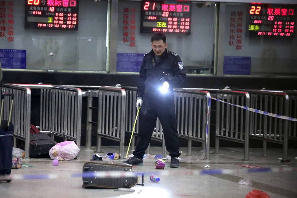 A Chinese police investigator inspects the scene of an attack at the train station in Kunming, southwest China's Yunnan province, on March 2, 2014, the day after over 10 attackers stabbed 29 people to death, and injured over 140 people. (STR/AFP/Getty Images)