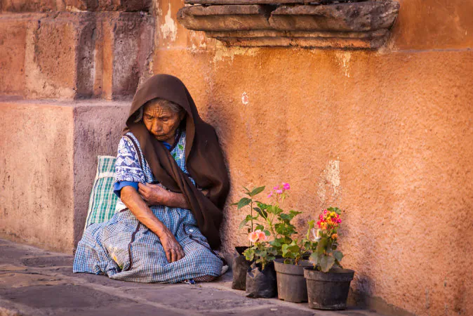 A file photo of an impoverished woman in San Miguel de Allende, Mexico. A Panama Newsroom article explores the impact of environmental policies on the poor who may bear the burden of having to pay for energy sources they can't afford. 