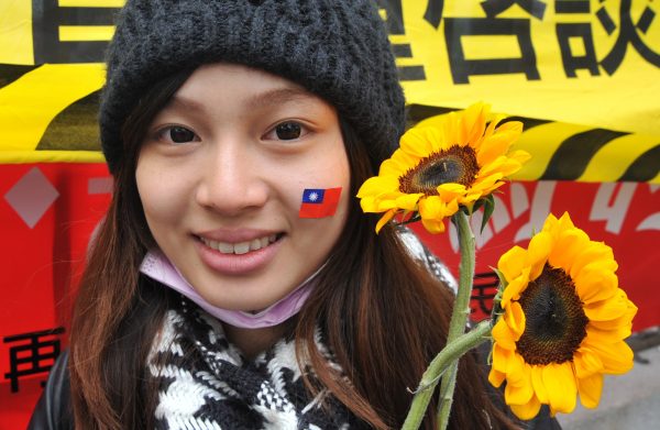 An activist holds sunflowers and wears a sticker of Taiwan's national flag on her face in support of student protesters occupying the parliament building in Taipei on March 21, 2014. Student protesters occupying Taiwan's parliament to stop the government from ratifying a contentious trade pact with China on March 21 vowed to take further action after the government failed to respond to their ultimatum. (Mandy Cheng/AFP/Getty Images)
