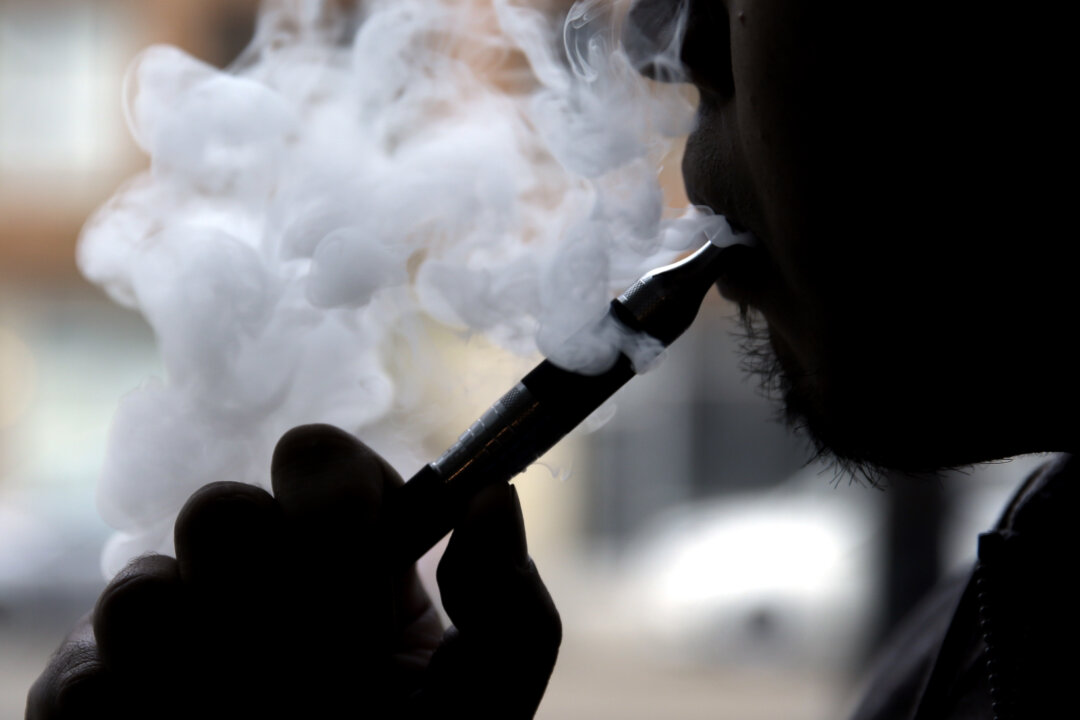 Daryl Cura demonstrates an e-cigarette at Vape store in Chicago, Wednesday, April 23, 2014. The federal government wants to ban sales of electronic cigarettes to minors and require approval for new products and health warning labels under regulations being proposed by the Food and Drug Administration. (AP Photo/Nam Y. Huh)
