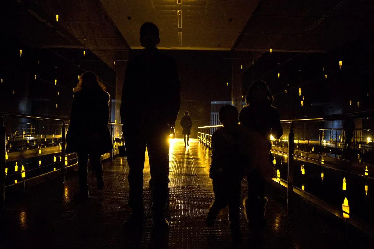 Visitors walk through a hall filled with yellow bulbs symbolizing massacre victims at Nanjing Massacre Memorial Hall in Nanjing, Jiangsu Province, China, on Feb. 11, 2014. (Alexander F. Yuan/AP Photo)  