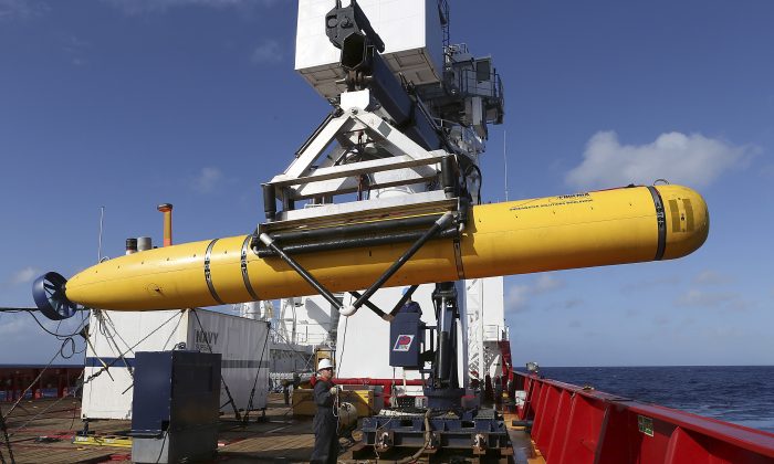 In this Thursday, April 17, 2014 photo provided by the Australian Defense Force the Phoenix International Autonomous Underwater Vehicle (AUV) Artemis is craned over the side of Australian Defense Vessel Ocean Shield before launching the vehicle into the southern Indian Ocean in the search of the missing Malaysia Airlines Flight 370.  Up to 11 aircraft and 12 ships continue to scan the ocean surface for debris from the Boeing 777 that disappeared March 8 en route from Kuala Lumpur to Beijing with 239 people on board. (AP Photo/Australian Defense Force, Bradley Darvill) EDITORIAL USE ONLY