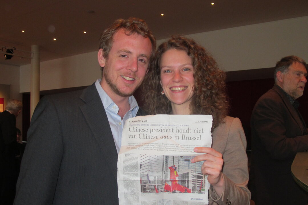 Audience members after being impressed with the Shen Yun performance display an article with a headline, ‘Chinese President Does Not Like Chinese Dance in Brussels.’ (Maria Mann/Epoch Times)
