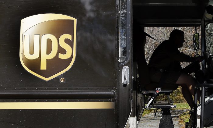 FILE - In this Monday, Oct. 22, 2012, file photo, a UPS driver drives after a delivery in North Andover, Mass. UPS reports quarterly earnings on Thursday, April 24, 2014. (AP Photo/Elise Amendola)