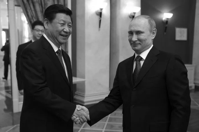 Russia’s President Vladimir Putin (R) shakes hands with Chinese Communist Party head Xi Jinping prior to a reception before the 2014 Winter Olympic Games opening ceremony in Sochi, on Feb. 7. Chinese Communist Party mouthpiece People’s Daily reported that Xi’s visit to Sochi was a sign of the “special bond” between the two nations. (ALEXEI NIKOLSKY/AFP/Getty Images)