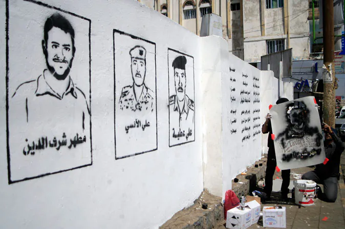 A Yemeni graffiti artist paints faces of victims of an al-Qaida militant attack on a wall during an 'anti-terrorism' campaign on March 6, 2014 in Sanaa. The victims were killed when a suicide bomber rammed an explosives-packed car into Yemen's defence ministry on December 5, 2013. (Mohammed Huwais/AFP/Getty Images)