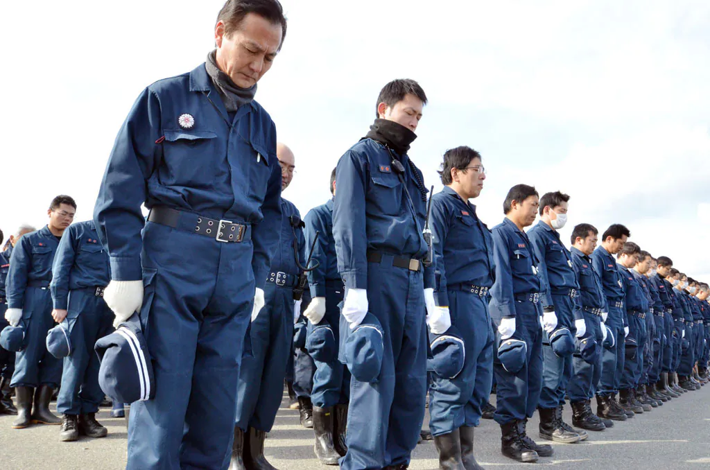 Police officers bow to offer prayers in silence for the victims in Namie, near the striken TEPCO Fukushima Dai-ichi nuclear plant in Fukushima prefecture on March 10, 2014, one day before the third anniversary of March 11 massive earthquake and tsunami. The 9.0 magnitude earthquake in 2011 sent a huge wall of water into the coast of the Tohoku region, splintering whole communities, ruining swathes of prime farmland and killing nearly 19,000 people. (Yoshikazu Tsuno/AFP/Getty Images)