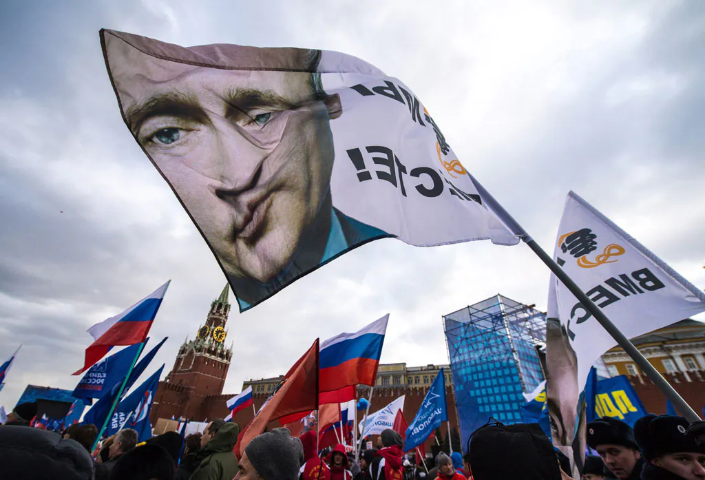With a flag depicting President Vladimir Putin (C) pro-Kremlin activists rally at the Red Square in Moscow, on March 18, 2014, to celebrate the incorporation of Crimea. Putin pushed today every emotional button of the collective Russian psyche as he justified the incorporation of Crimea, citing everything from ancient history to Russia's demand for respect to Western double standards. (Dmitry Serebryakov/AFP/Getty Images)