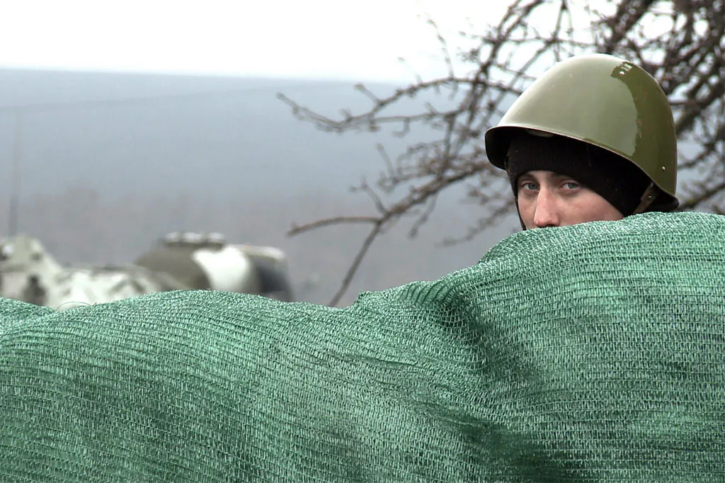 A Ukrainian soldier guards a road not far from Prokhody, a village in the Kharkiv region, some 4 kilometers from the Russian border, on April 5, 2014. Officially, these Ukrainian conscripts are conducting military exercises, but with a reported 40,000 Russian troops gathered along the border just weeks after annexing Crimea, these soldiers have been deployed to repel an invasion from invisible but feared troops amassed on the other side. (Robert Leslie/AFP/Getty Images)