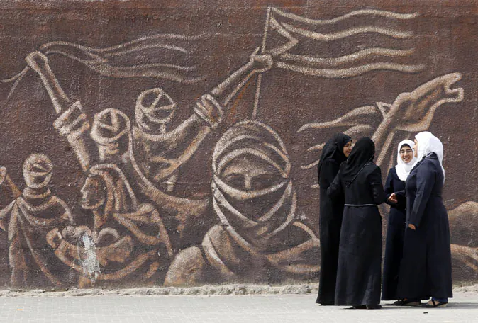 Palestinian schoolgirls stand in front of a mural during an awareness training session on dangers of unexploded ordinance on April 7, 2014 at a school in Khan Younis in the southern Gaza Strip. (Said Khatib/AFP/Getty Images)