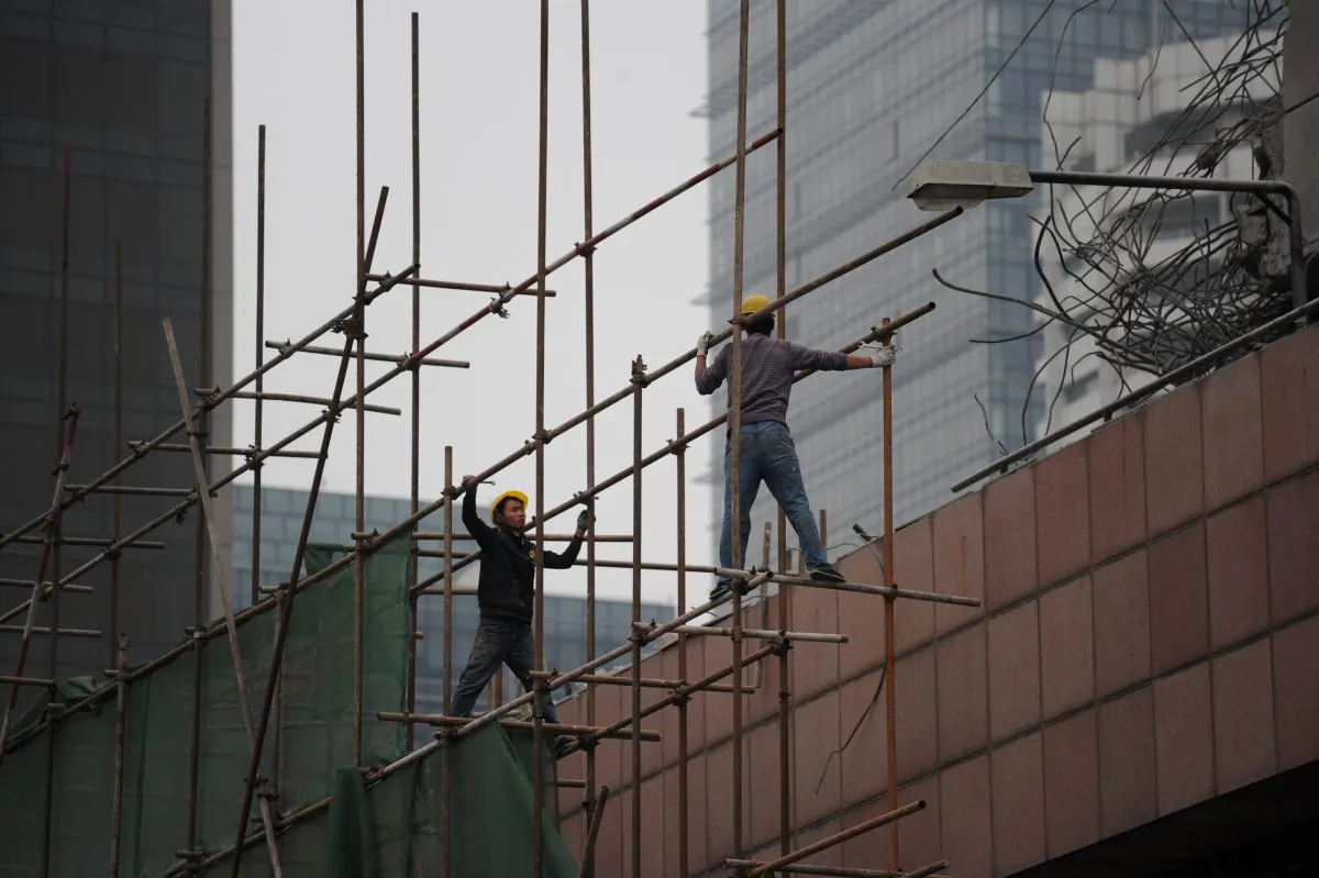 Two Chinese workers prepare to remove scaffolding at a construction site in Beijing on April 15, 2014. Chinese economic data came in roughly as expected in the first quarter of 2014. (Wang Zhao/AFP/Getty Images)