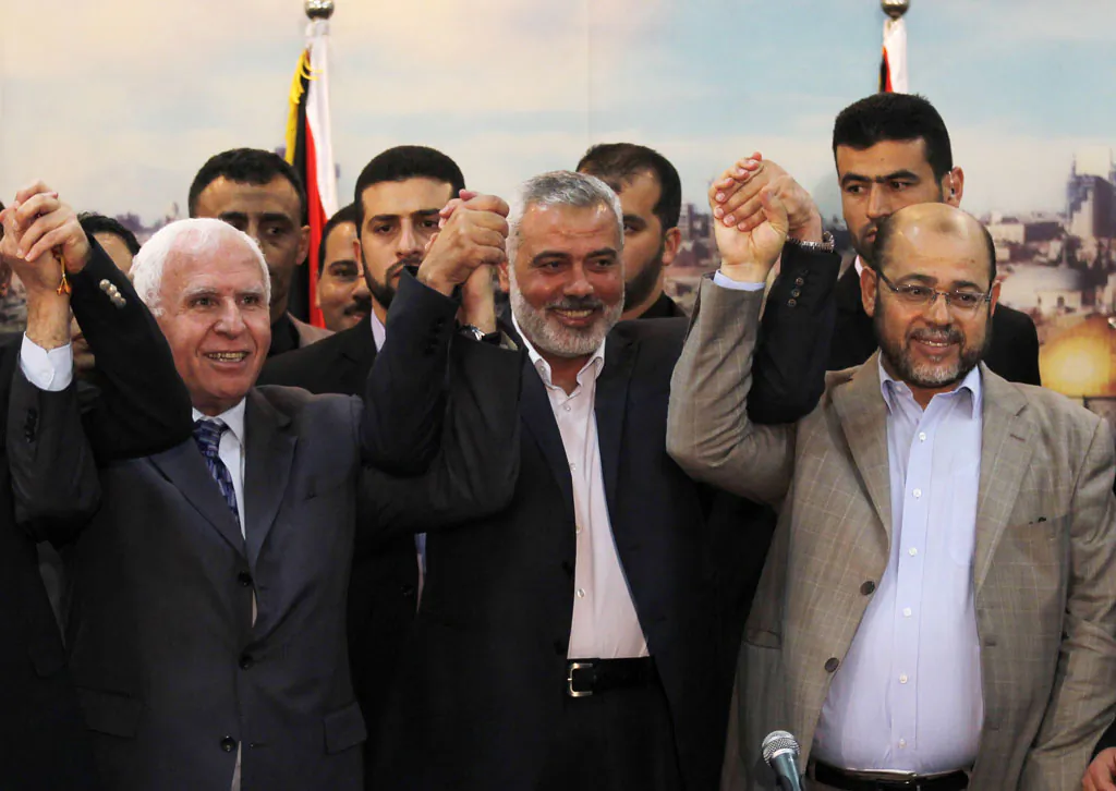 Palestinian Fatah delegation chief Azzam al-Ahmed, Hamas prime minister in the Gaza Strip Ismail Haniya and Hamas deputy leader Musa Abu Marzuk pose for a photo as they celebrate in Gaza City on April 23, 2014 after West Bank and Gaza Strip leaders agreed to form a unity government within five weeks as peace talks with Israel face collapse. Under the rapprochement between the Palestine Liberation Organisation (PLO) -- internationally recognised as the sole representative of the Palestinian people -- and the Islamist Hamas which rules Gaza, the sides agreed to form a 'national consensus' government within weeks. (Said Khatib/AFP/Getty Images)