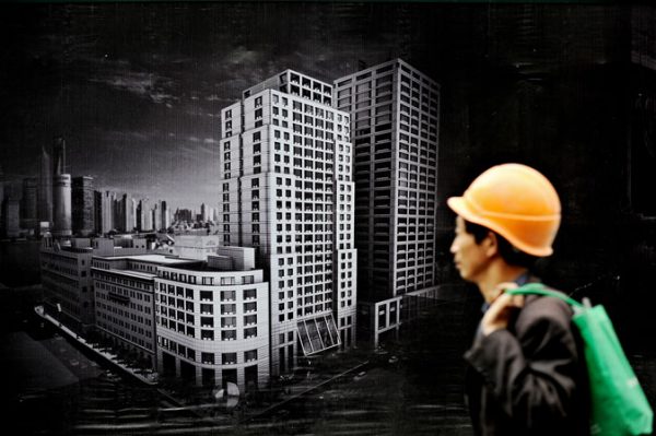 A worker walks past a billboard advertising a new real estate project in Shanghai. China is likely to introduce a property tax on residential housing in the first half of the year as part of its attempts to curb spiralling real estate prices, state media reported on April 26, 2010. (Philippe Lopez/AFP/Getty Images)