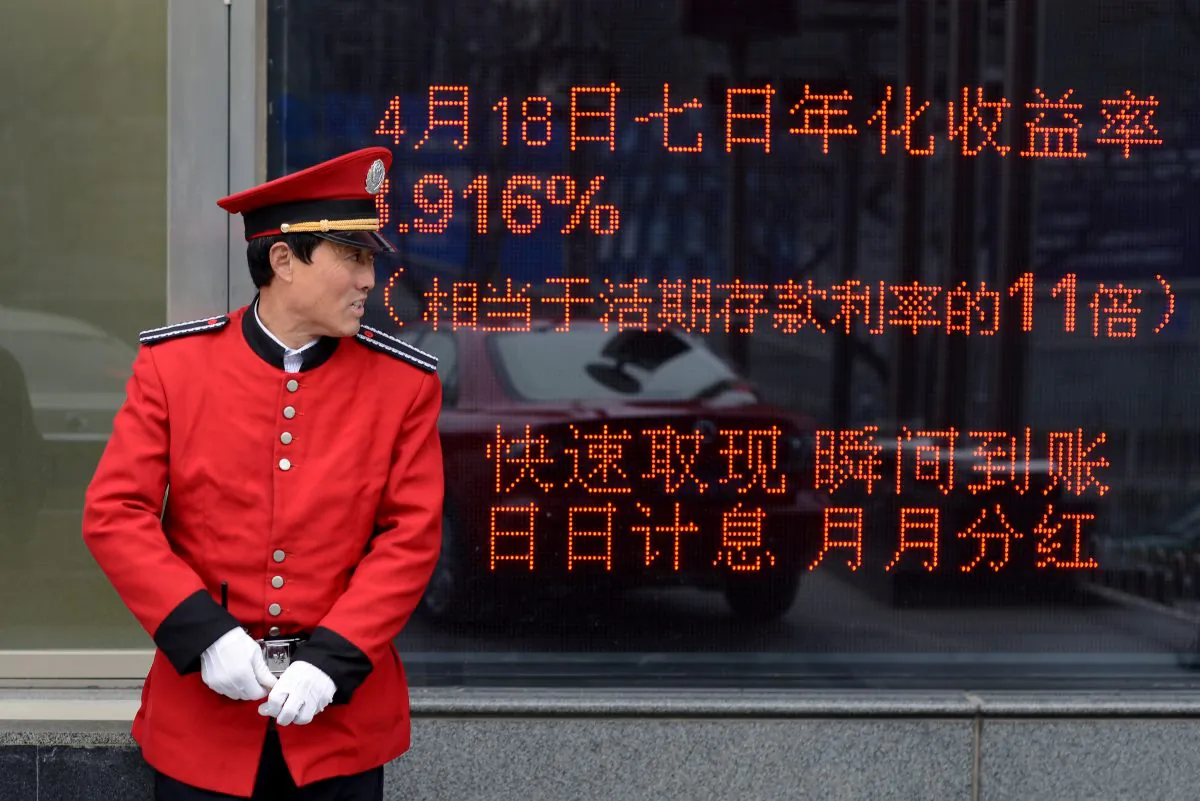 A guide standsin front of an electronic board at the entrance of a bank in Beijing on April 23, 2013. ( WANG ZHAO/AFP/Getty )