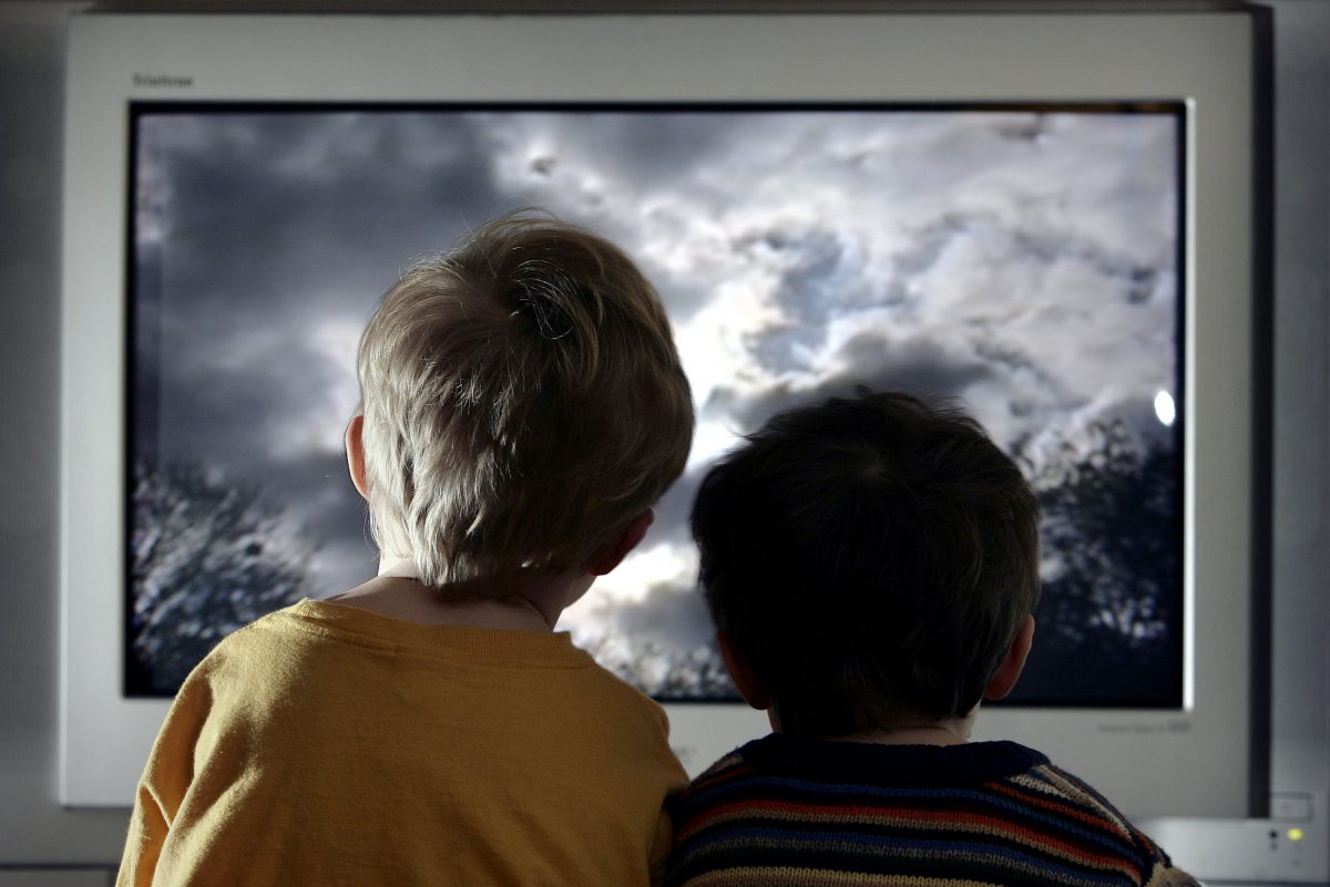 In this file photo illustration, two young child watch television at home. (Peter Macdiarmid/Getty Images)