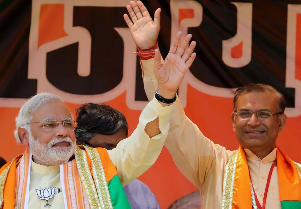 India's Bharatiya Janata Party (BJP) prime ministerial candidate Narendra Modi (L) and BJP candidate for Hazaribagh Parliamentary constituency Jayant Sinha wave to supporters during an election rally in Hazaribagh, India's Jharkhand state, on April 15, 2014. (STR/AFP/Getty Images)