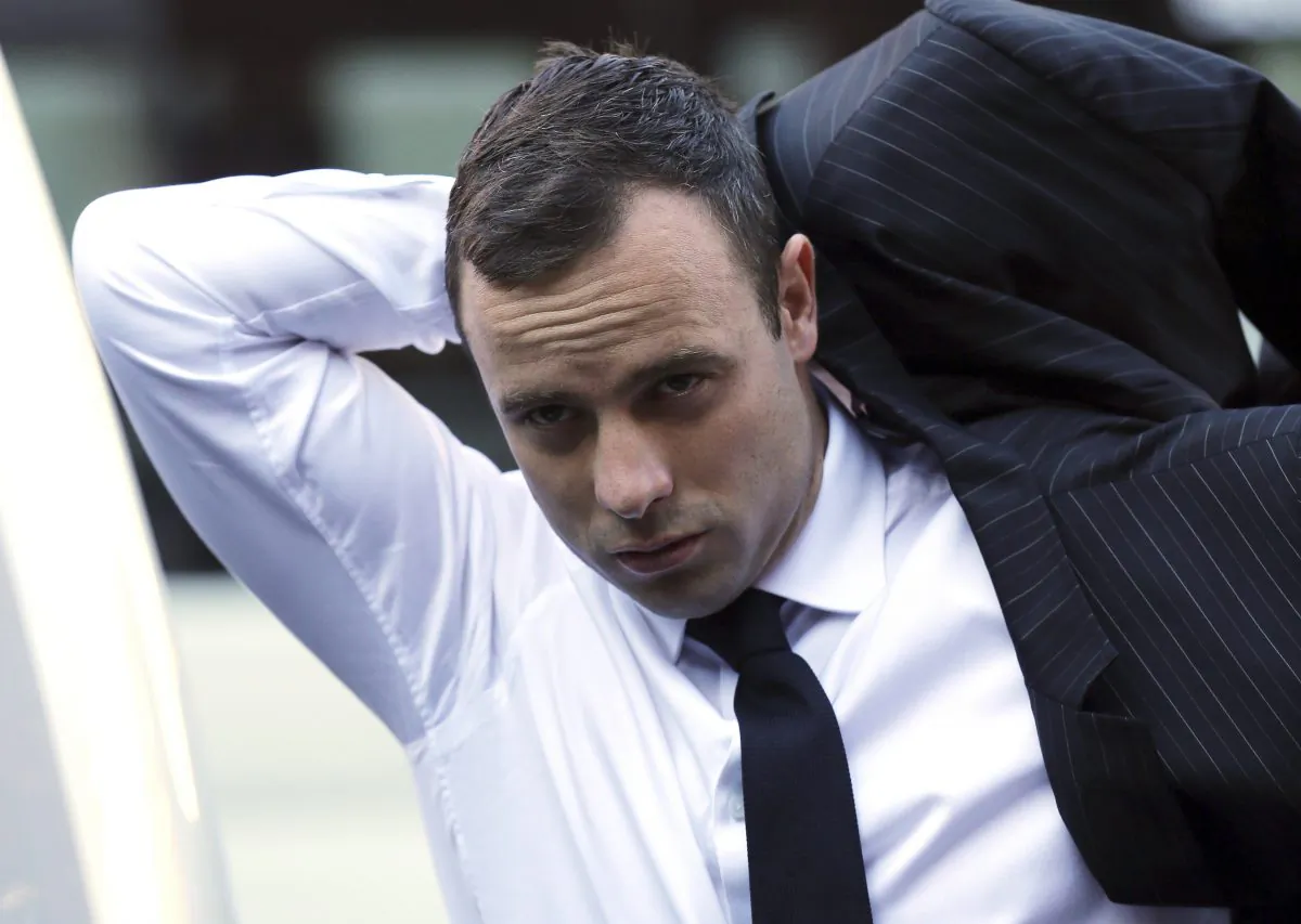 Oscar Pistorius puts on his jacket as he arrives at the high court in Pretoria, South Africa, on April 11, 2014. (AP Photo/Themba Hadebe)